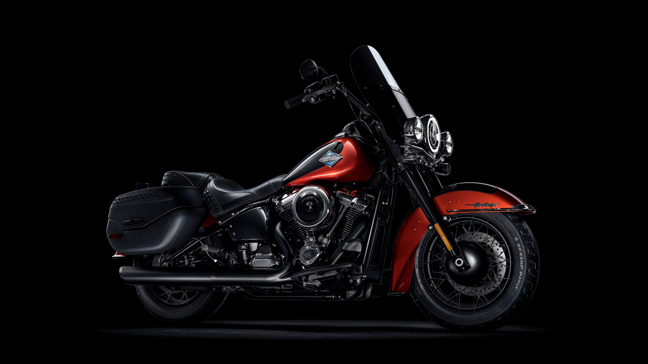 Black and red 2025 Harley-Davidson® Heritage Classic parked against a black studio backdrop.