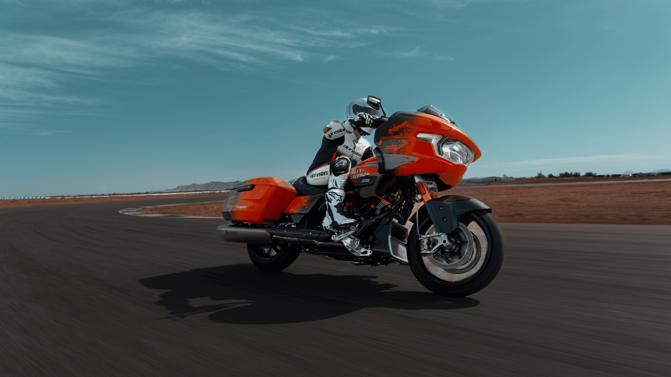 A professional rider leans into a turn on the track aboard the 2025 Harley-Davidson® Road Glide® RR, a high-performance bagger built for speed.