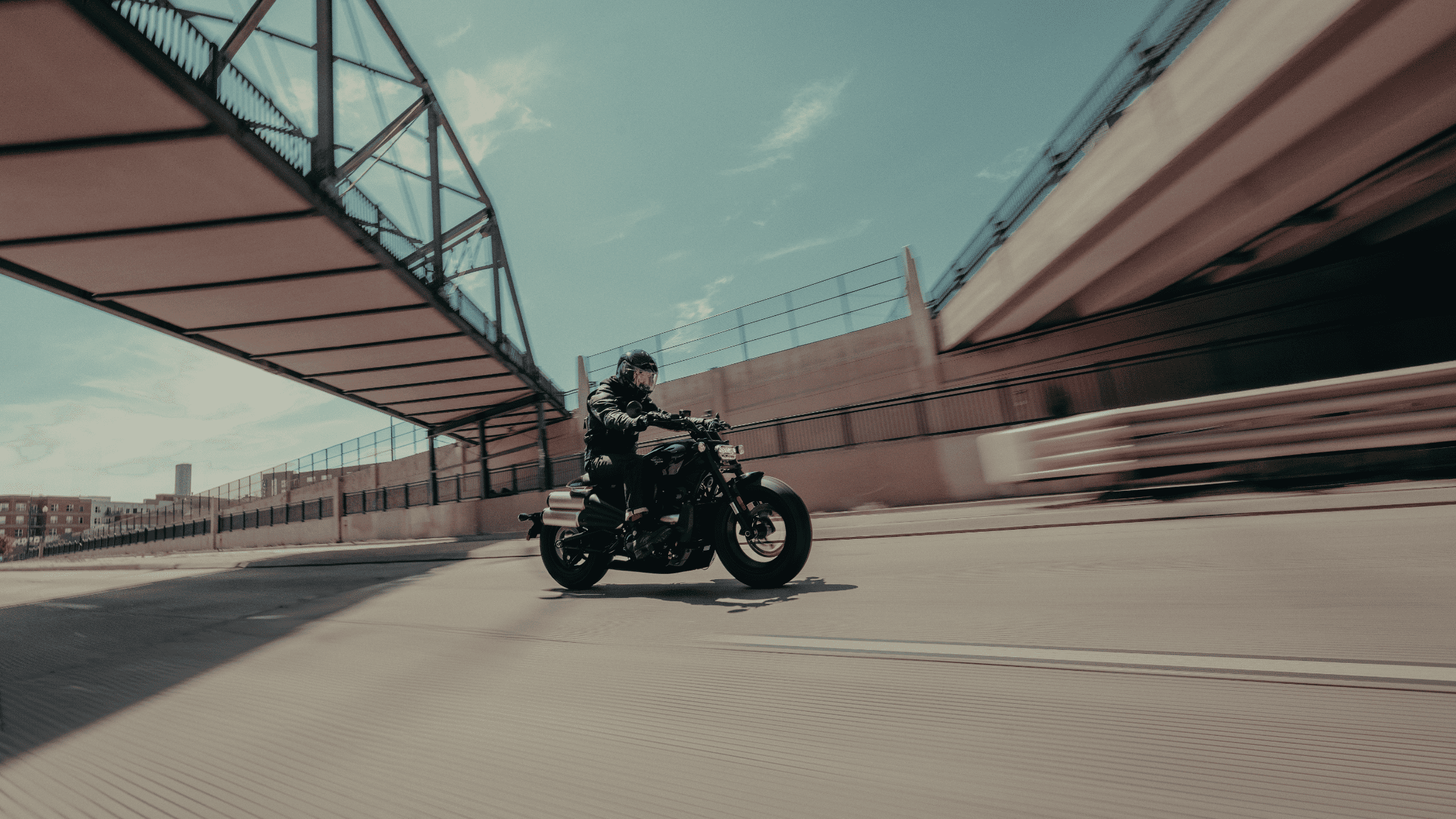 2025 Harley-Davidson Sportster S in matte black, ridden through an urban overpass, showcasing its aggressive stance