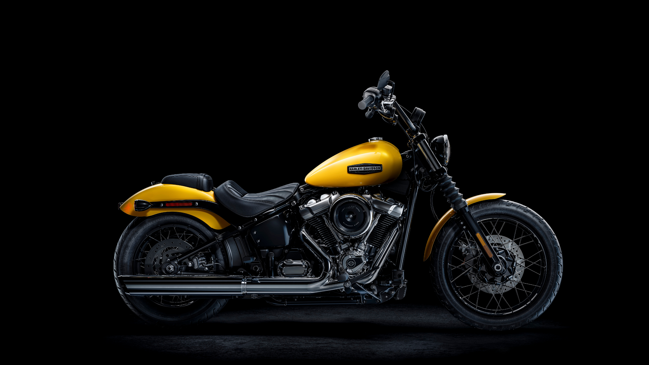Yellow 2025 Harley-Davidson® Street Bob motorcycle in profile view against a dark backdrop.