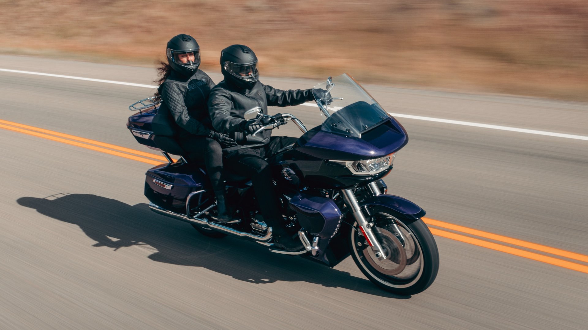 2026 Harley-Davidson® Road Glide® Limited touring motorcycle with rider and passenger cruising on an open highway.