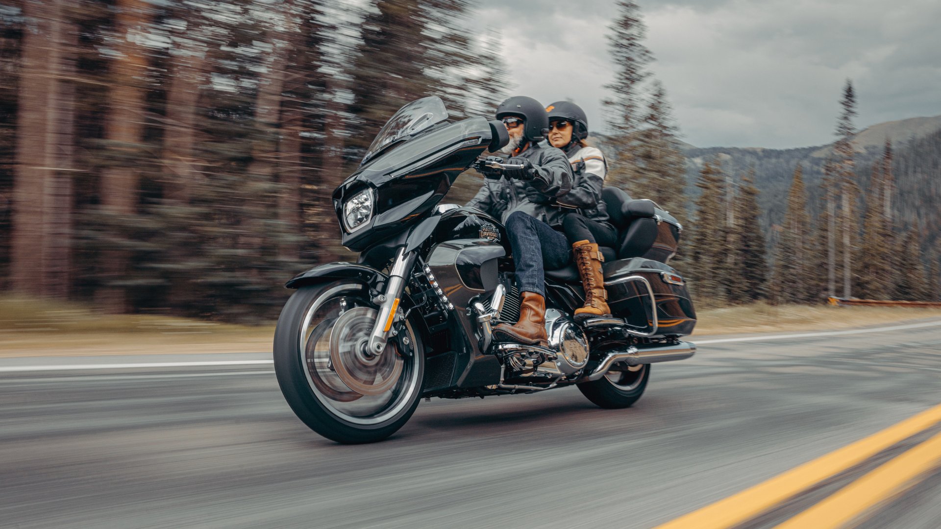 2026 Harley-Davidson® Street Glide® Limited touring motorcycle ridden by two riders on a forest mountain road.